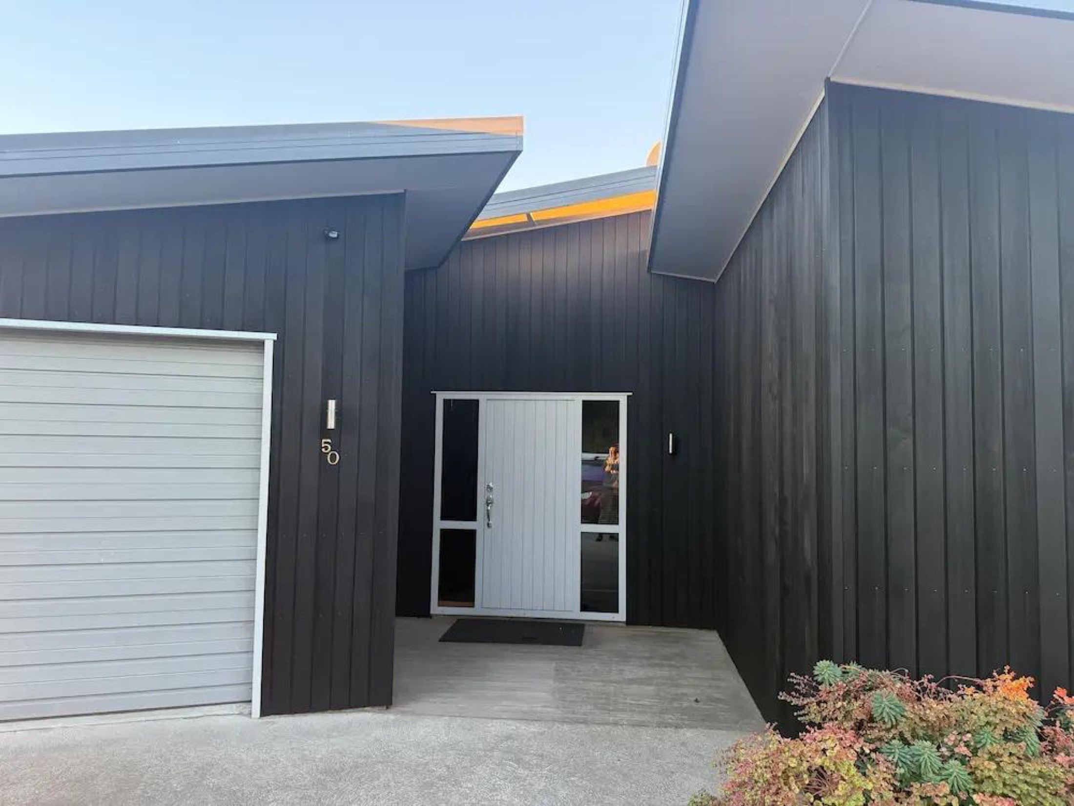 Restored cedar cladding at front entry after stain refresh, Wanaka