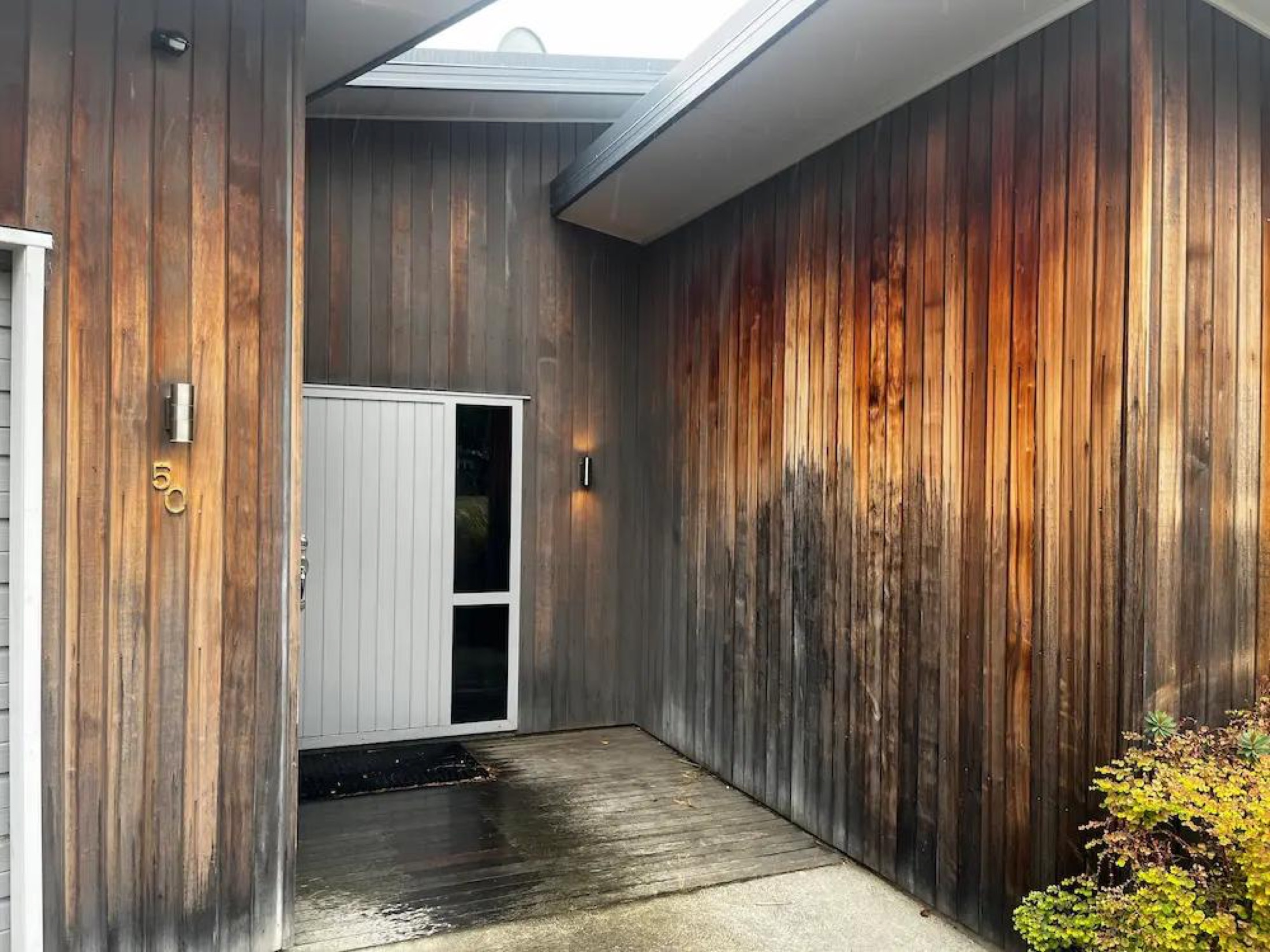 Weathered cedar cladding at front entry before staining, Wanaka